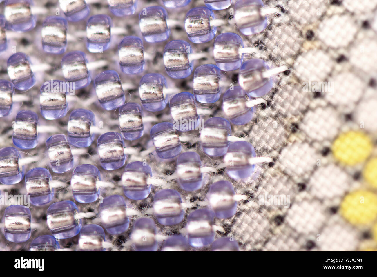Foto macro di porpora beadwork sulla tela. Foto Stock