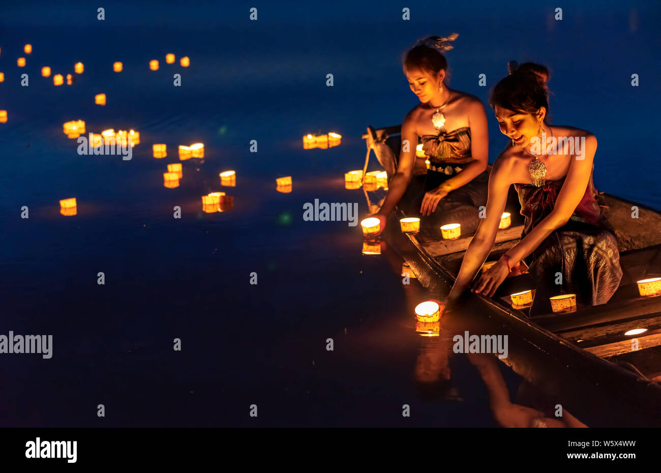 Giovani ragazze asiatiche lanterne galleggianti nel lago. Il festival può provenire da un antico rituale pregando rispetto all'acqua alcolici. Foto Stock