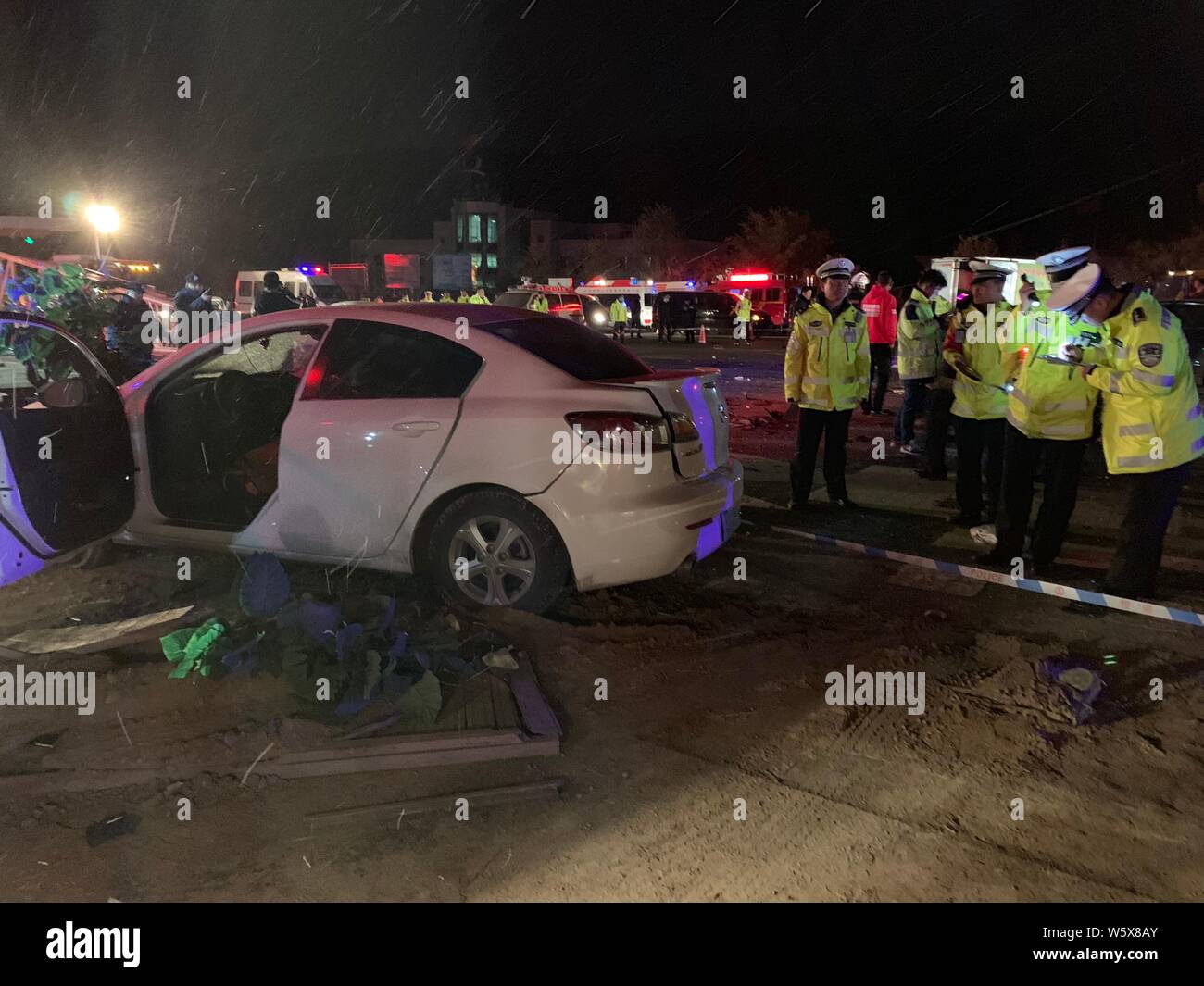 Poliziotti cinesi indagare sito incidente dopo una torre-autogru perso il controllo e si è schiantato in una linea di automobili in attesa a Lanzhou così Foto Stock