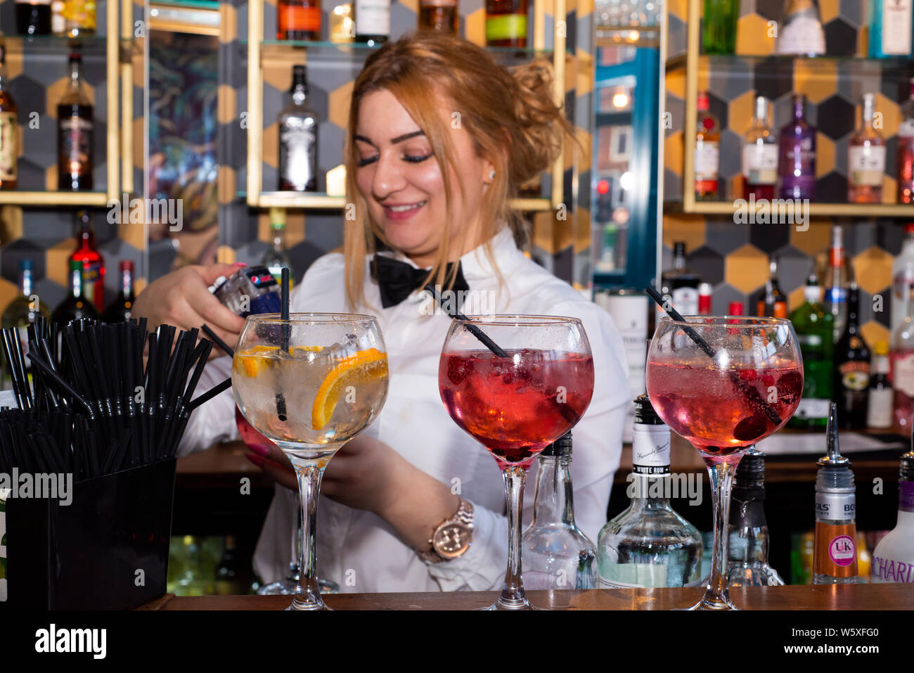 Doncaster, Regno Unito - 11 Maggio 2019: un sorridente cameriera mix di cocktail colorati dietro il bar a La Boca ristorante & steakhouse, 1 strada Netherhall Foto Stock