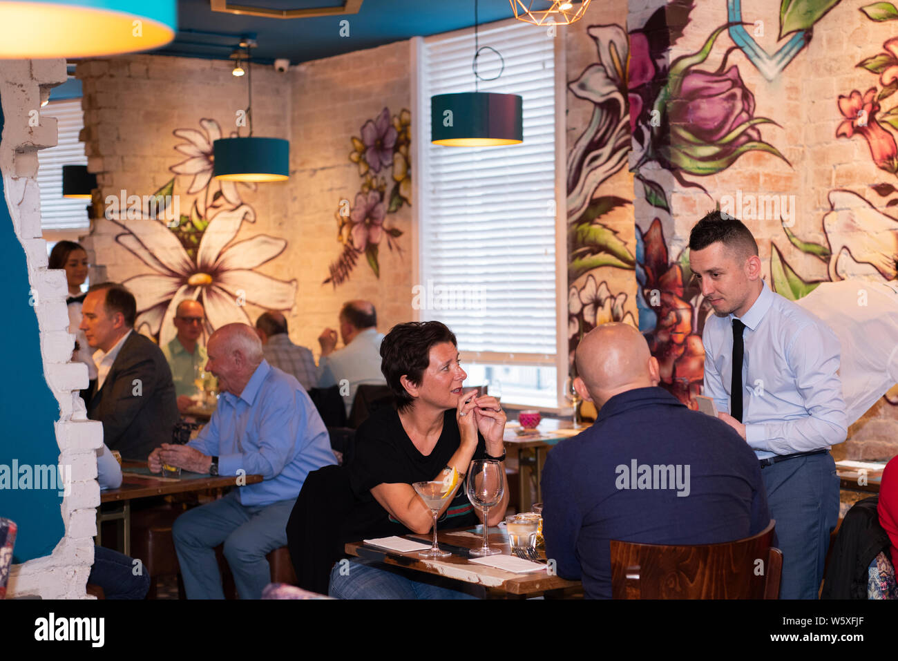 Doncaster, Regno Unito - 11 Maggio 2019: il manager del ristorante e controlli host in con i commensali in elegante Argetine themed La Boca steakhouse sabato 11 Ma Foto Stock