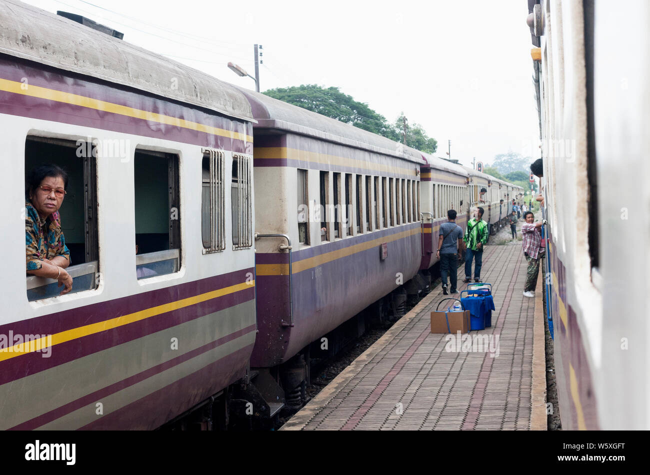 Thailandese donna che guarda attraverso la finestra e in attesa di una stazione ferroviaria a Bangkok, in Thailandia. Foto Stock