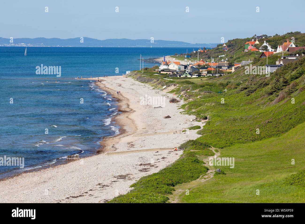 Vista lungo la spiaggia e il villaggio per la terraferma svedese in distanza, Rageleje, Regione Hovedstaden, Zelanda, Danimarca, Europa Foto Stock