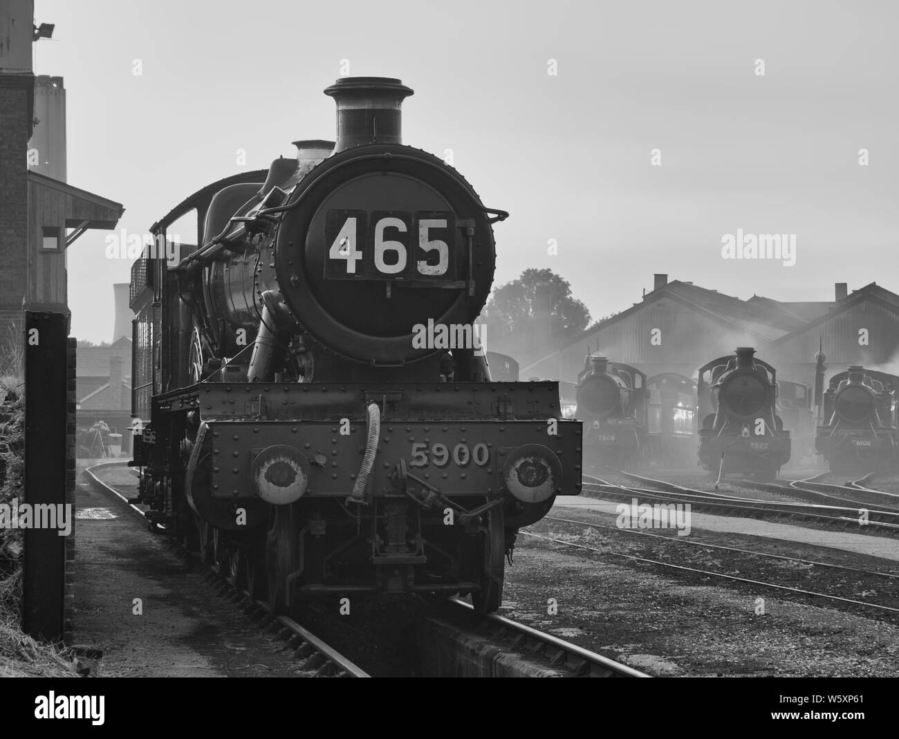 Ricreazione nostalgica di una scena del capannone ferroviario dell'era del vapore, in bianco e nero, enfatizzando i giorni passati della gloria. Foto Stock