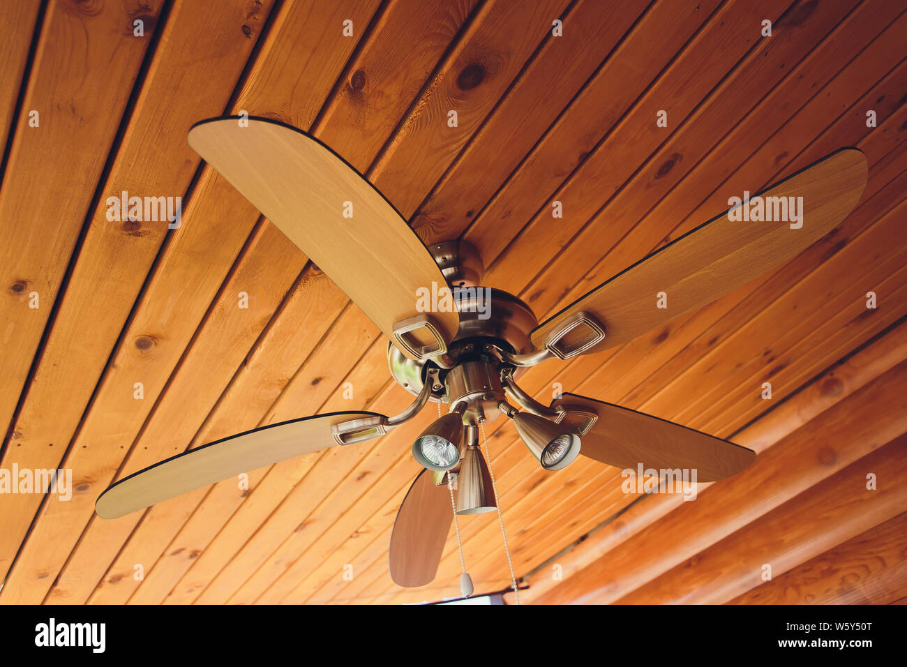 Ventilatore da soffitto su esposta una trave di supporto, con un soffitto a  volta interamente in legno, nel salotto di una casa moderna, con spazio per  il testo sulla parte superiore e