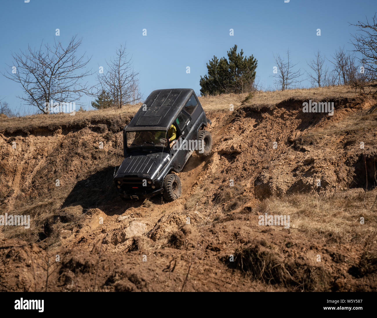 4x4 carrello suv guidando in discesa sul bordo della collina. Off road concept Foto Stock