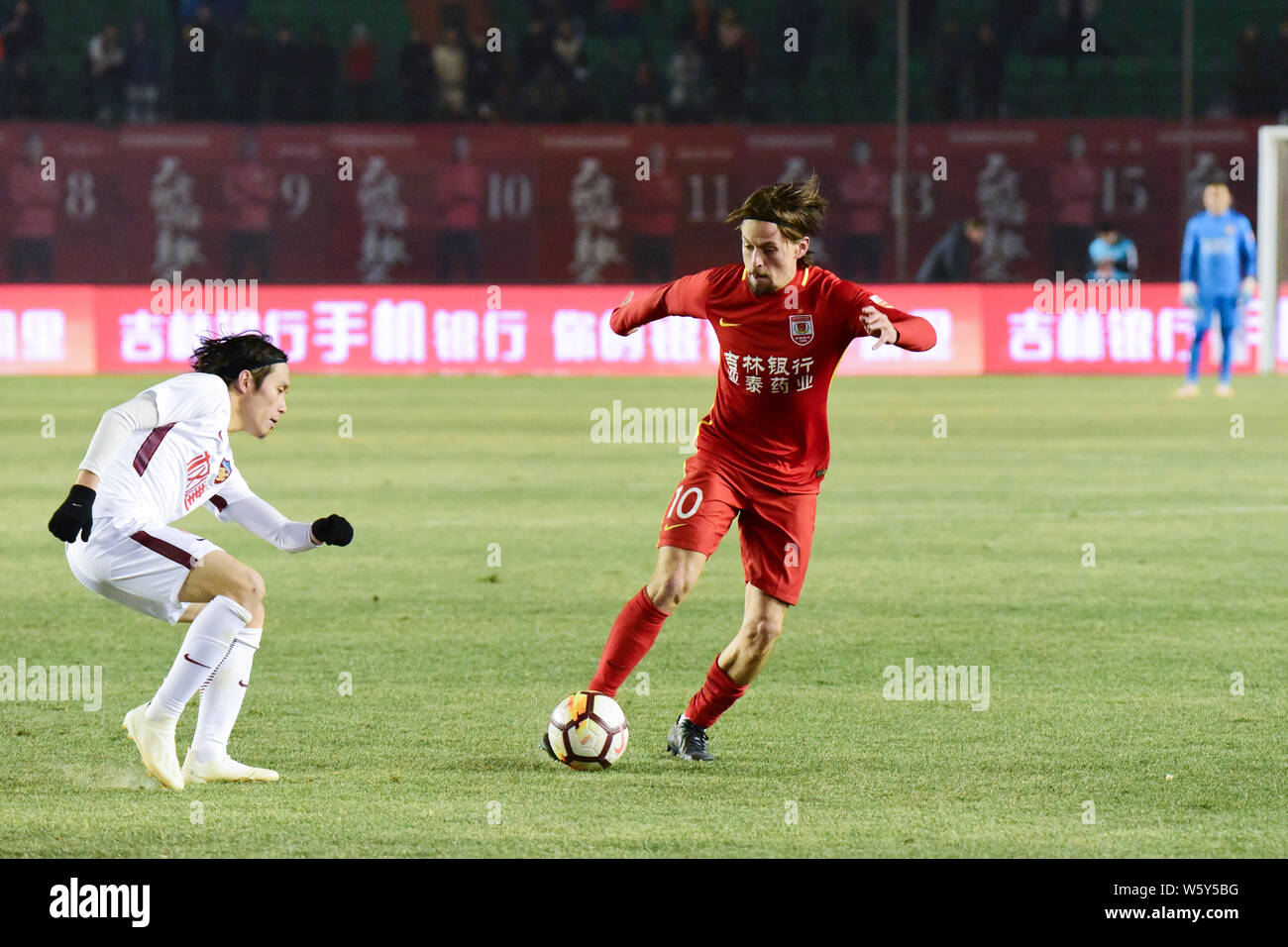 Il calcio danese player Lasse Vibe, sinistro di Changchun Yatai dribbling contro un giocatore di Tianjin Quanjian nella ventinovesima partita durante il 2018 mento Foto Stock