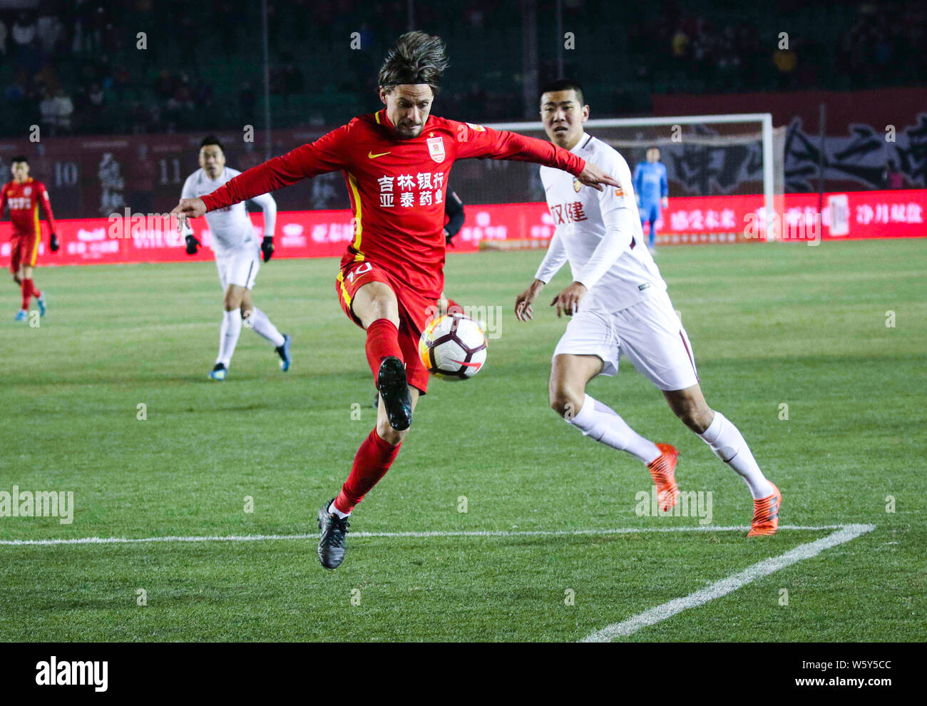 Il calcio danese player Lasse Vibe, sinistro di Changchun Yatai dribbling contro un giocatore di Tianjin Quanjian nella ventinovesima partita durante il 2018 mento Foto Stock