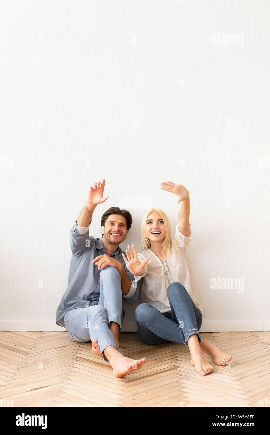 Coppia felice la pianificazione e la discussione del progetto di design per la casa nuova Foto Stock