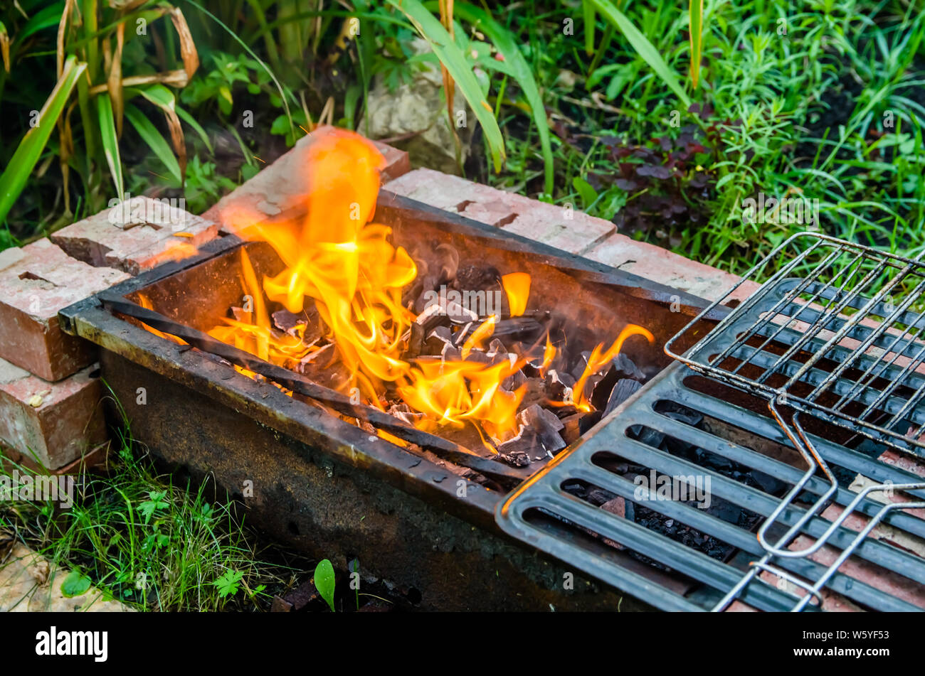 Fuoco arde nel grill nel giardino Foto Stock