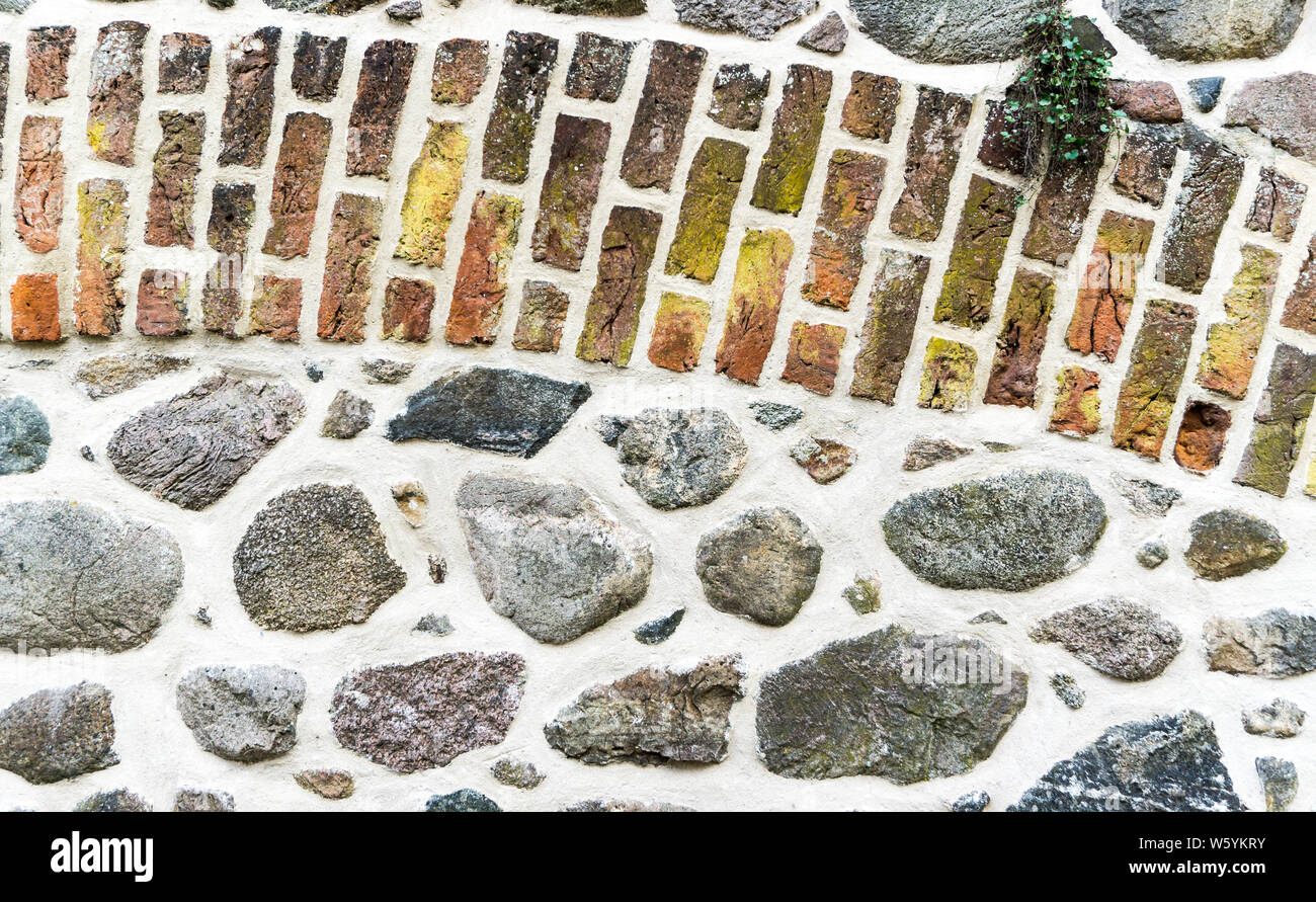 Muro di pietre di campo e i mattoni colorati Foto Stock