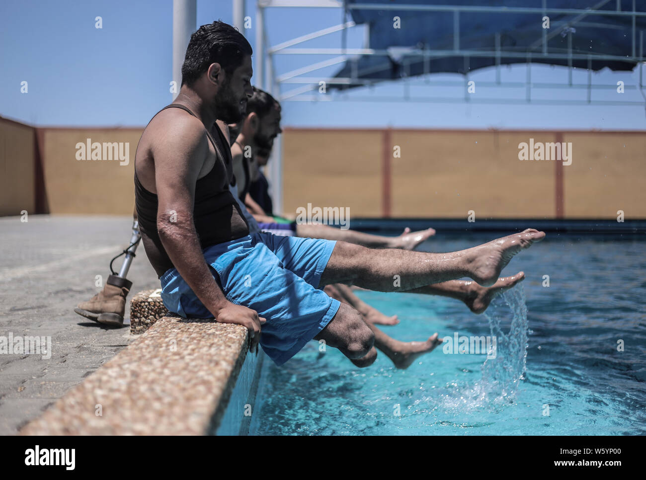 Persone amputate palestinese, che ha perso una gamba a cicli di violenza con Israele, prendere parte in una piscina sessione di formazione in Gaza City. Foto Stock