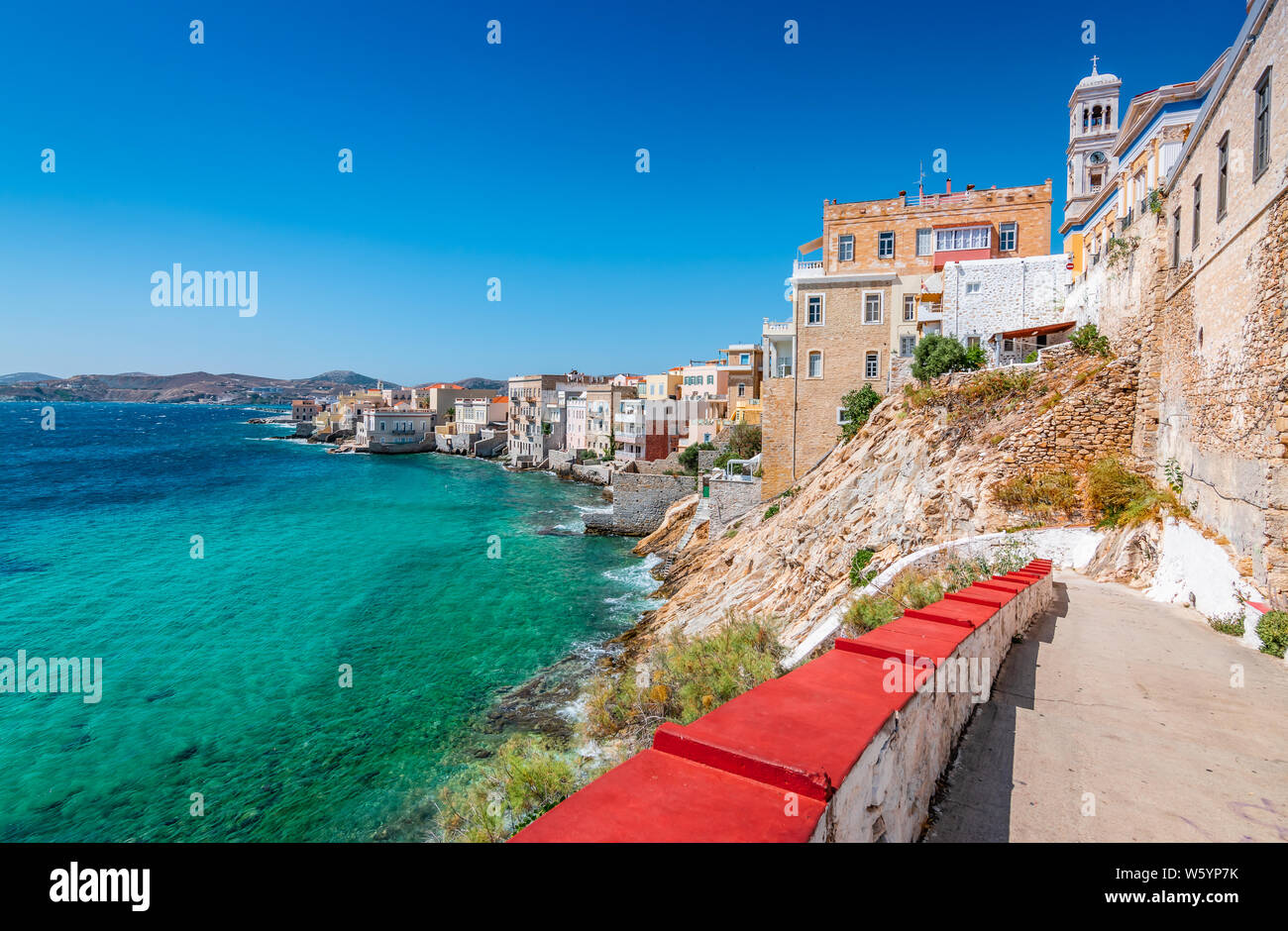 Vaporia distretto della città di Ermoupoli, Syros Island. Paesaggio con edifici lungo la costa e le scale per la spiaggia. Foto Stock
