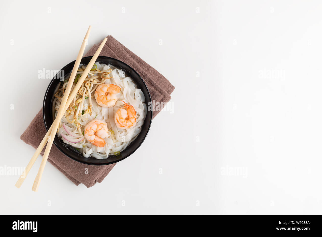 Tradizionale vietnamita noodle soup Pho con gamberetti in vaso nero su sfondo bianco Foto Stock