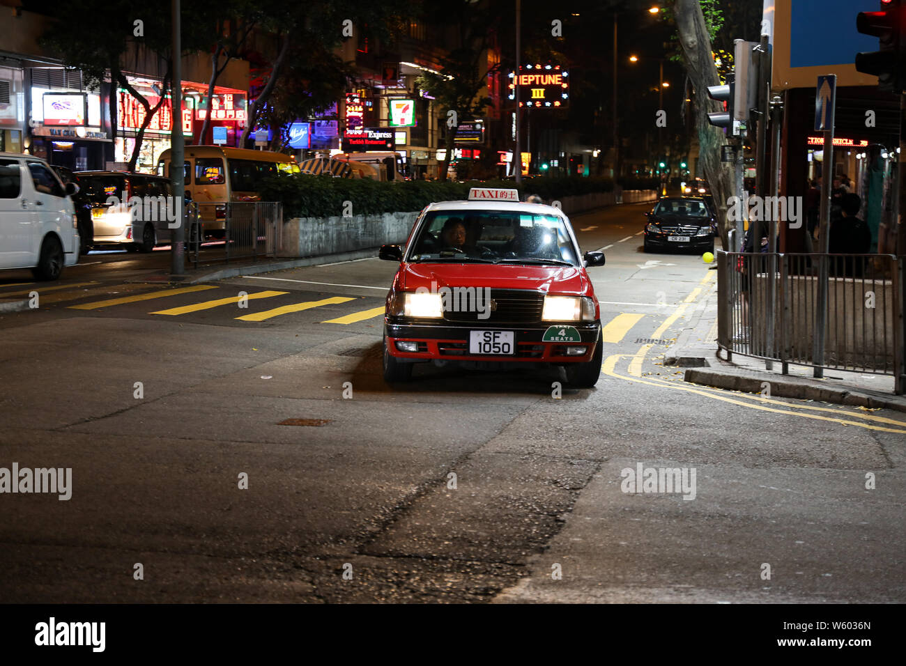 Immagine notturna panoramica di taxi urbano rosso un angolo illuminato strada a WAN Chai, Hong Kong Foto Stock