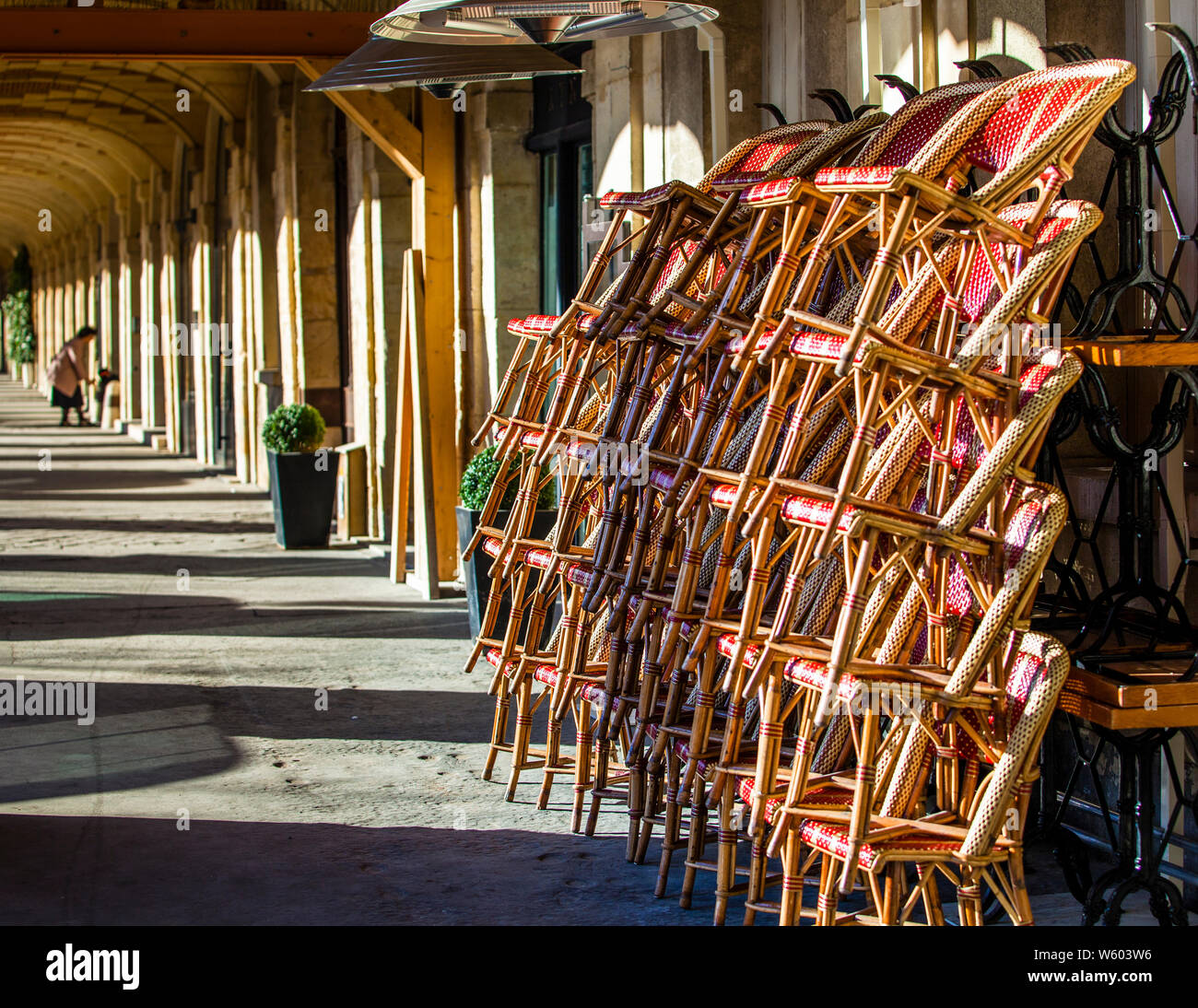 Bistrot chiuso. Le sedie del bistrot si accumulano in un colonnato a Parigi, in Francia Foto Stock