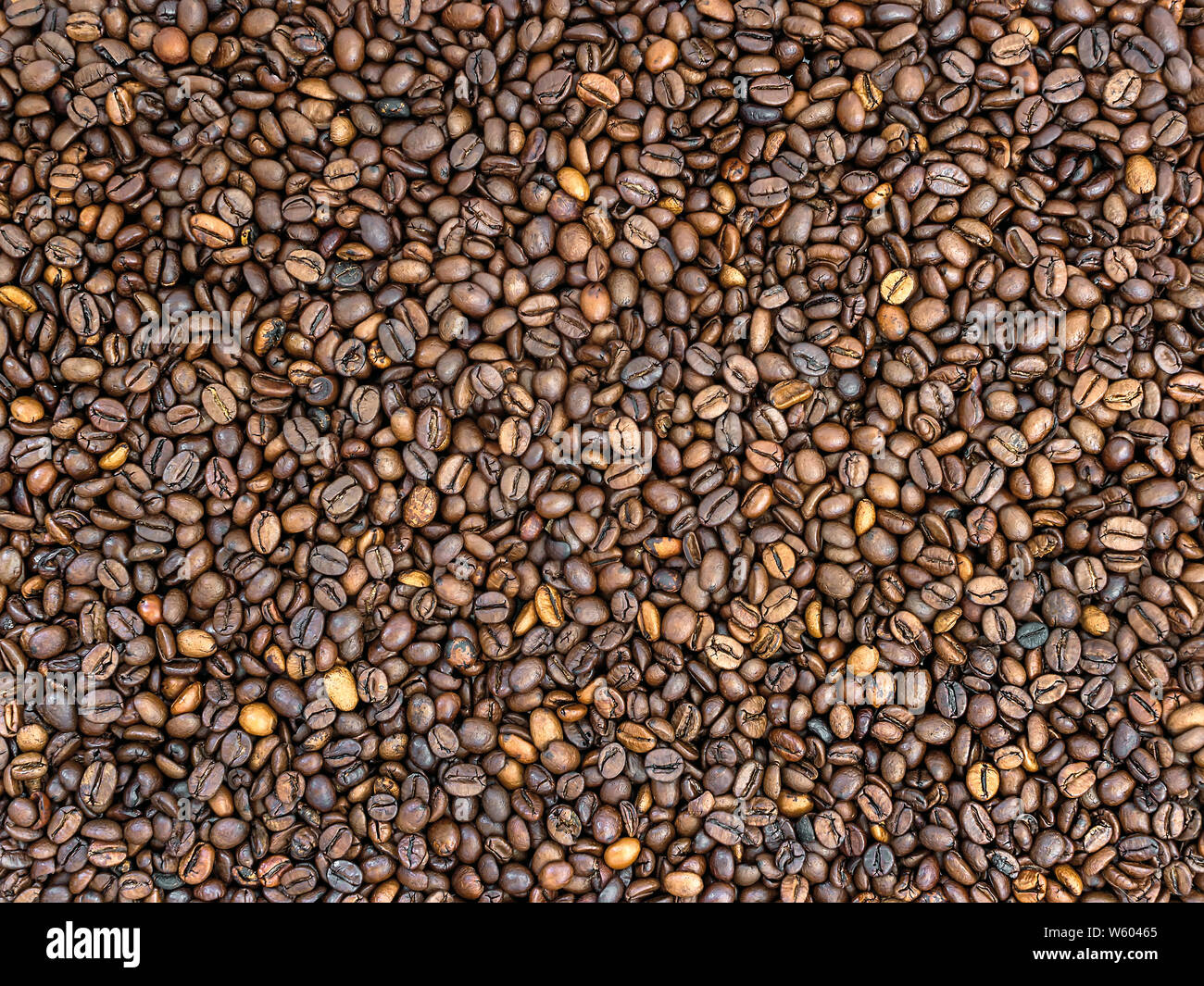 Rosolare i chicchi di caffè texture. Mix di buio e di medie caffè torrefatto in grani. Può essere usato come cibo e bevanda sfondo. Vista dall'alto. Foto Stock