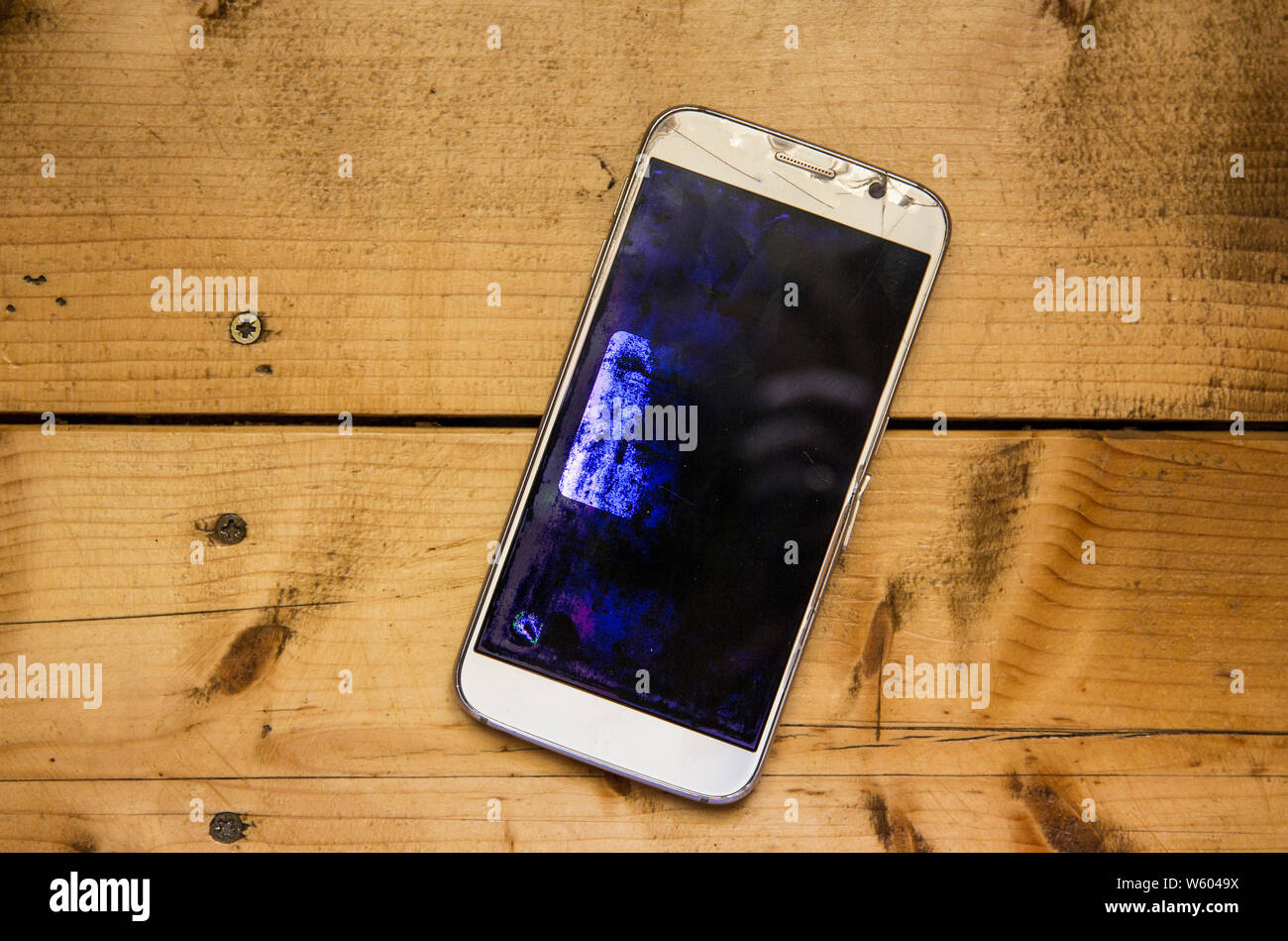 Vista superiore dello smartphone display a cristalli liquidi illuminato e  rotto sul pannello di legno con uno sfondo con spazio di copia Foto stock -  Alamy