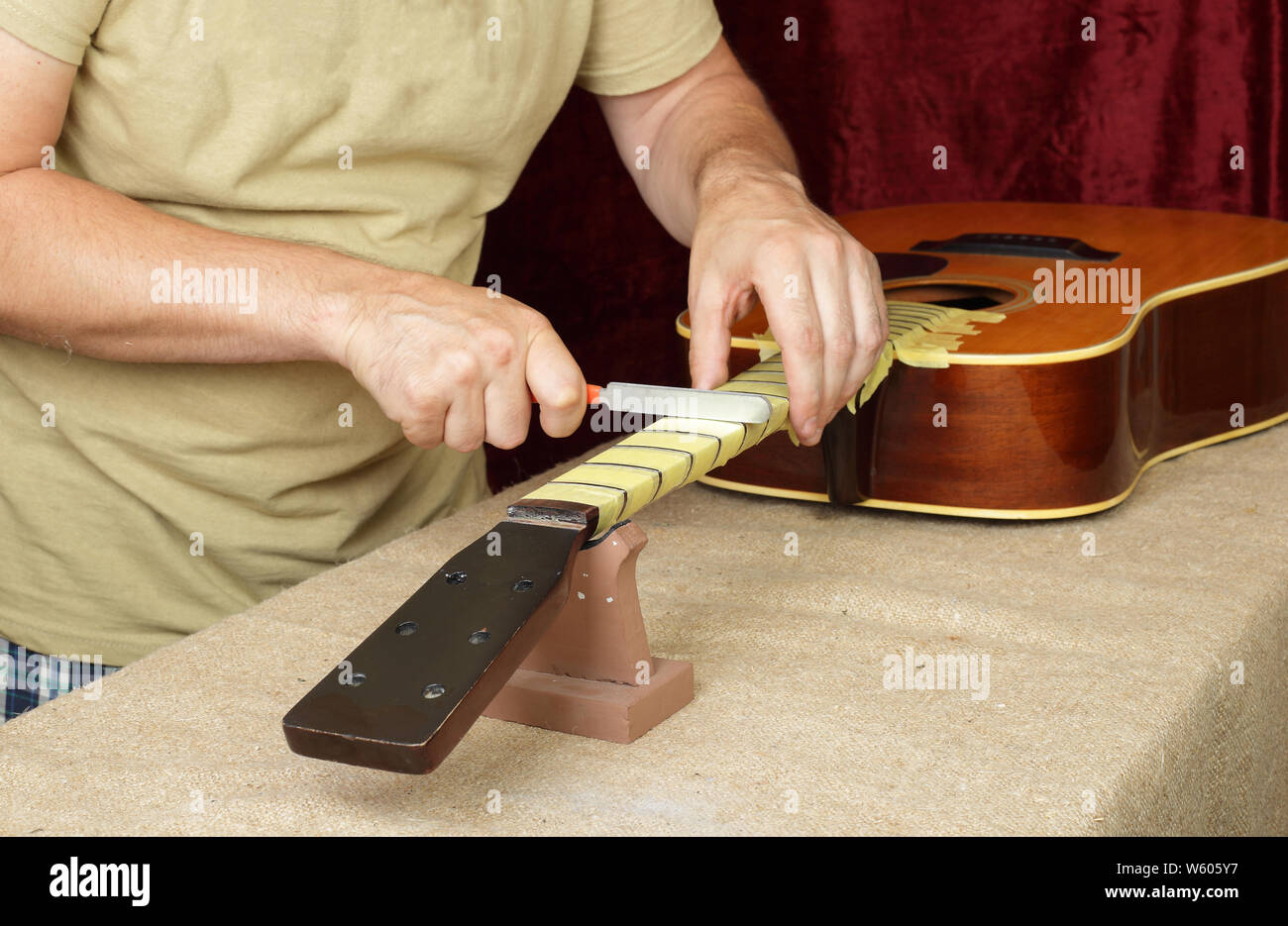Strumento musicale guitar di riparazione e di manutenzione - Lavoratore  affilare attrezzo speciale ponte dado servo nero chitarra acustica Foto  stock - Alamy
