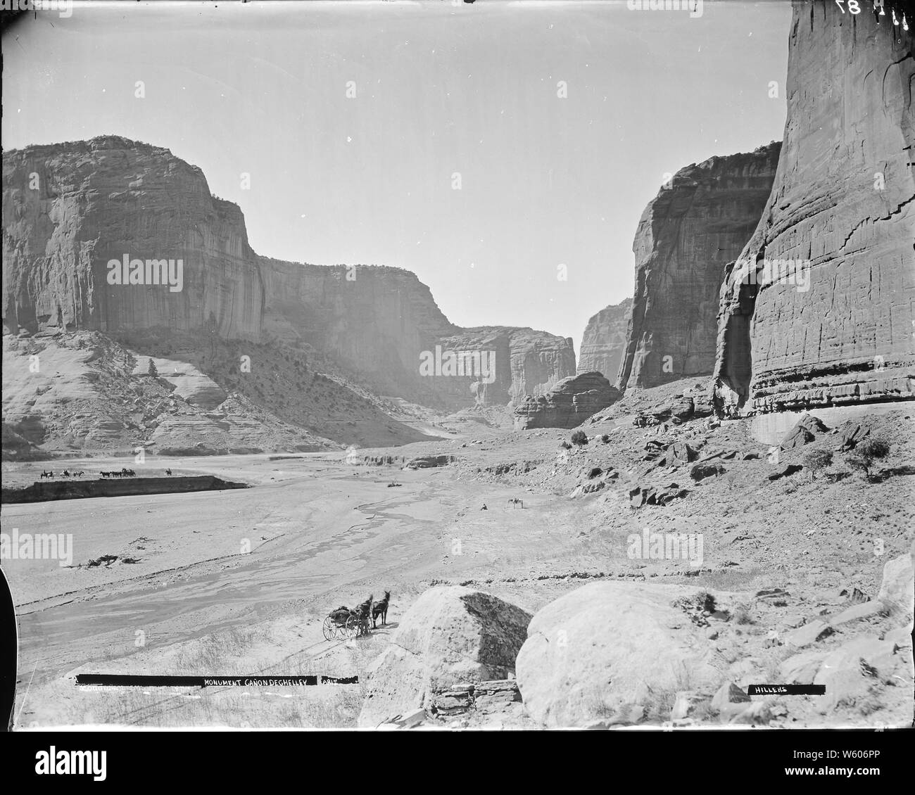 (Vecchia n. 114) monumento Canyon De Chelly, Arizona. Hillers foto. Un uomo è in piedi accanto a un due-carro cavalli nel centro di primo piano, forse maggiori Powell. Due carri con cinque uomini e tre uomini e cavalli vicino al centro sinistra della foto. Un grande mula bianca con un uomo seduto su un terreno a pochi metri di fronte ad essa vicino al centro a destra della foto., 1871 - 1878 Foto Stock