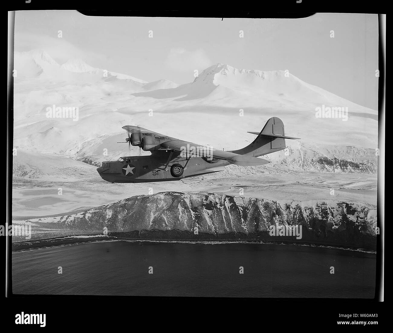 Una costruttiva PBY-5una pattuglia di Catalina crociere bombardiere contro uno sfondo di snow-rivestiti montagne in isole Aleutian, ricerca per attività nemiche.; Note Generali: Inglese: U.S. Navy costruttiva PBY consolidato-5A Catalina di patrol squadron VP-61 su Alaska (USA), marzo 1943. Foto Stock