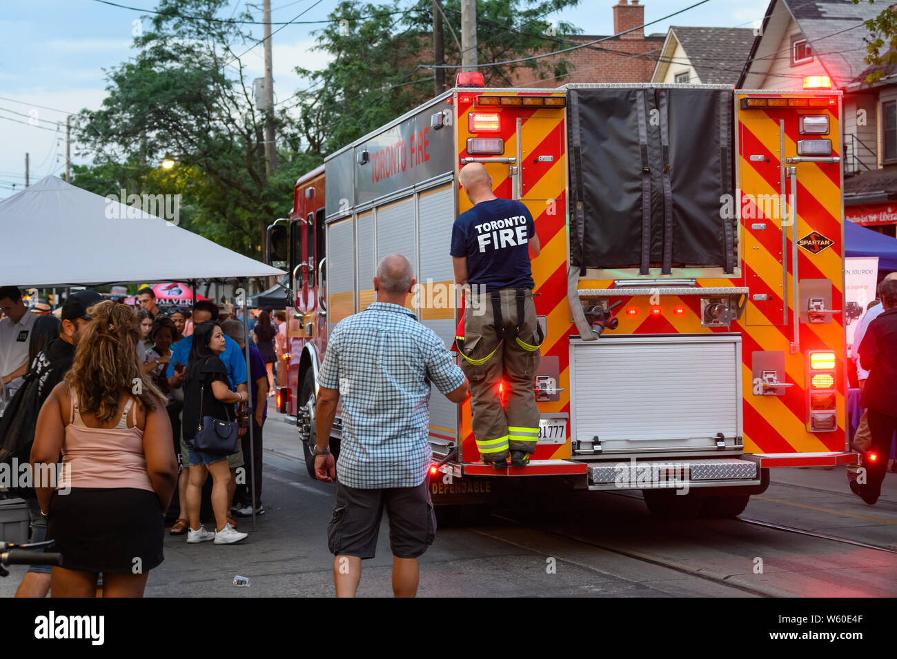 Un firetruck cerca di rendere il suo modo attraverso la strada affollata a Toronto il Streetfest, parte del Jazzfest music festival nel mese di luglio 2019. Foto Stock