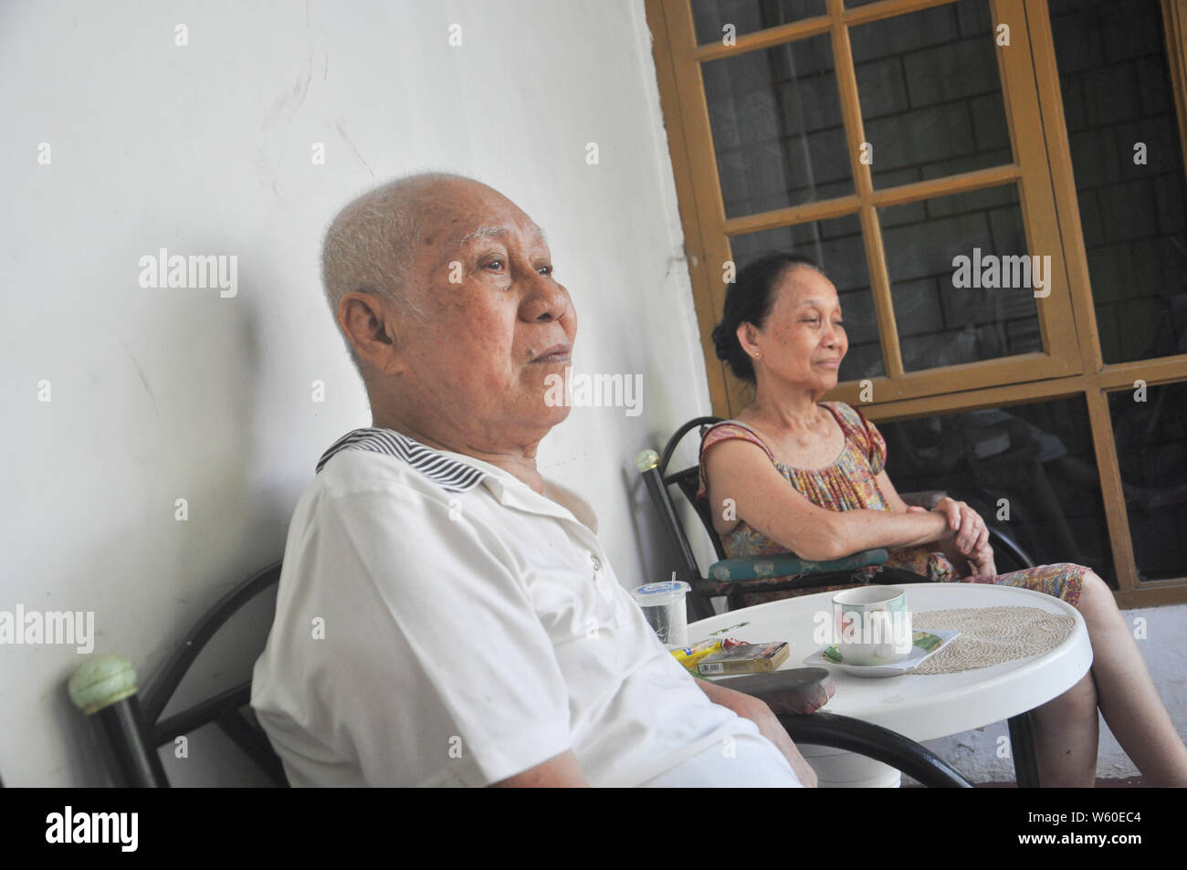 Andarias Sarra (L) , 80, e sua moglie Dortje Nony (R), 73, sedersi in veranda della casa nel villaggio Kapasa. Il sig. Sarra sopravvive da due attacchi di corsa. Egli Foto Stock