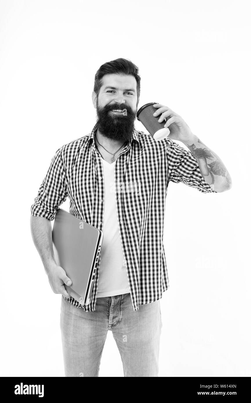 Essendo mobili. Happy guy tenendo chiuso portatile per uso mobile. Tech Computer con un dispositivo mobile bere il tè o il caffè sul piede. Uomo Barbuto godendo la sua bevanda calda e internet mobile. Foto Stock