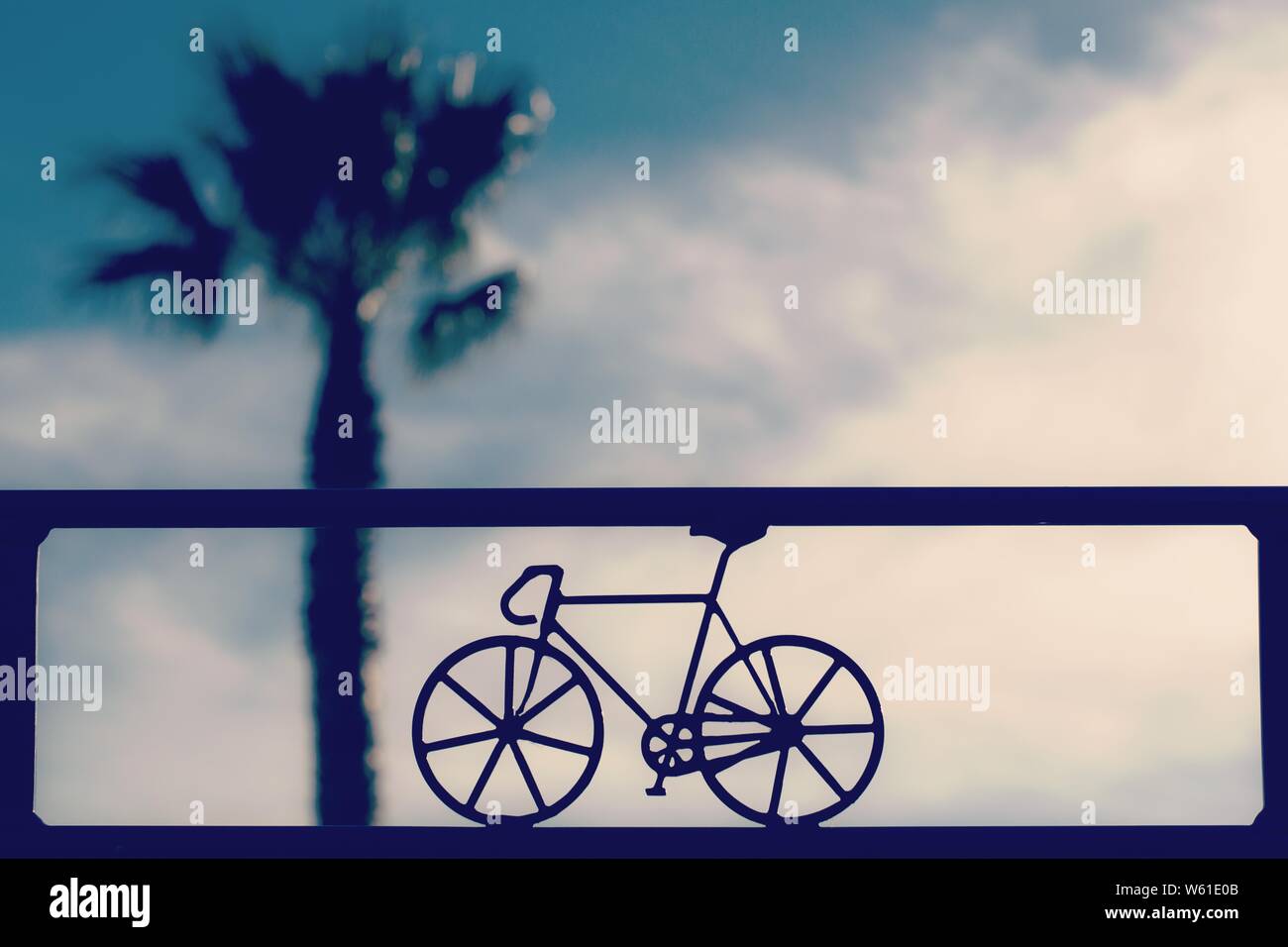 Primo piano di una piccola bicicletta decorativa su una ringhiera in metallo con un bellissimo sfondo naturale Foto Stock