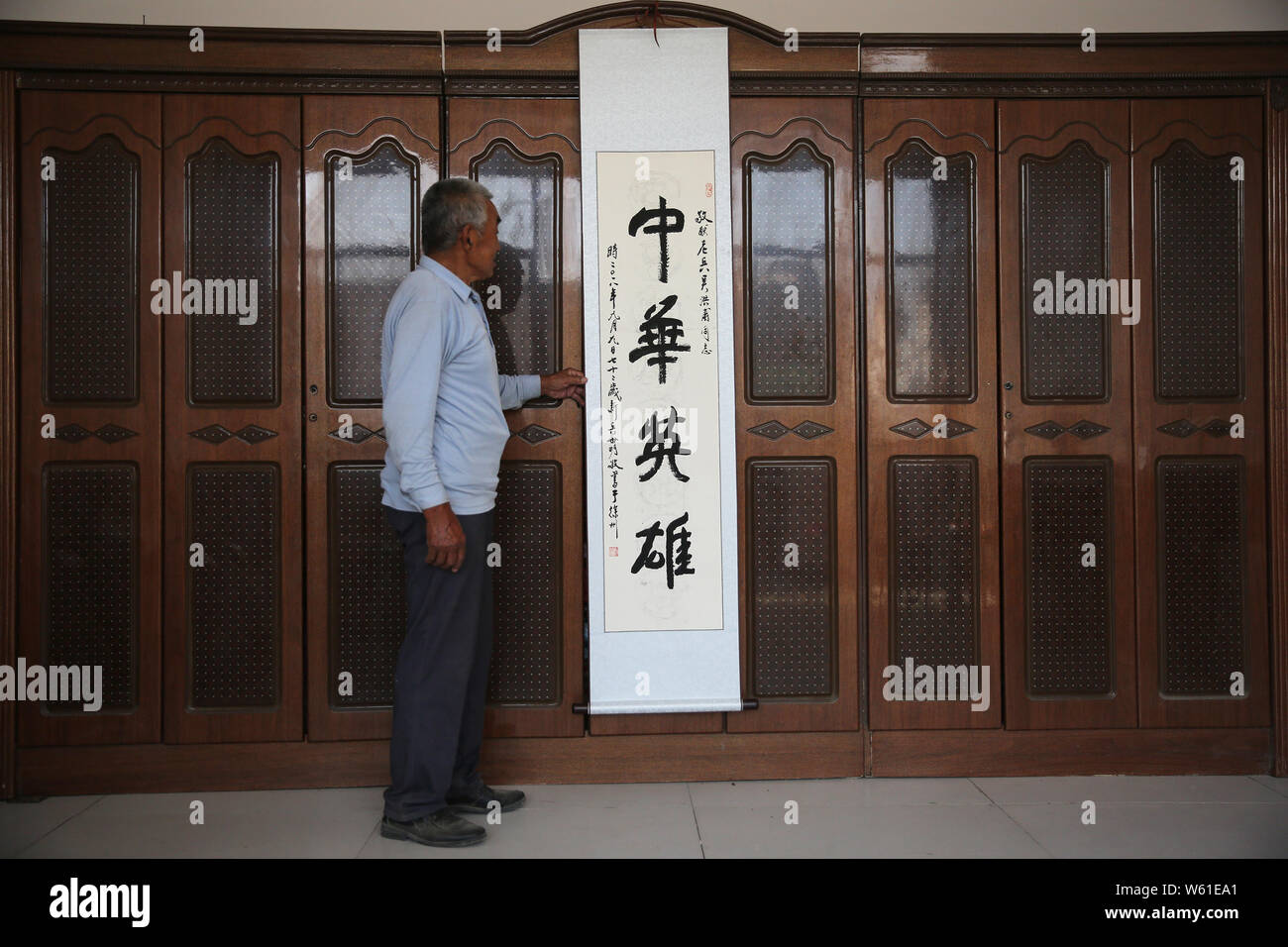 Il veterano cinese Wu Hongfu, che ha girato giù americano aerei di ricognizione U-2 due volte negli anni sessanta, mostra una calligrafia scorrere dicendo "eroe cinese' scritta Foto Stock