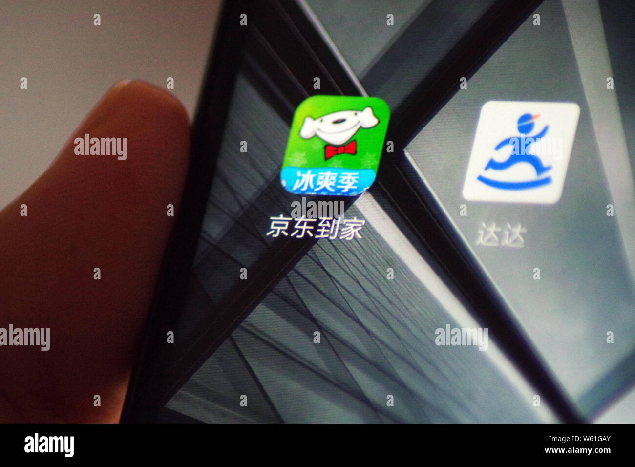 --FILE--un cinese telefono cellulare utente guarda le icone di Dada Express, destra e negozio di generi alimentari piattaforma di e-commerce JD Daojia (JDDJ) sul suo smartphone in Ji'na Foto Stock