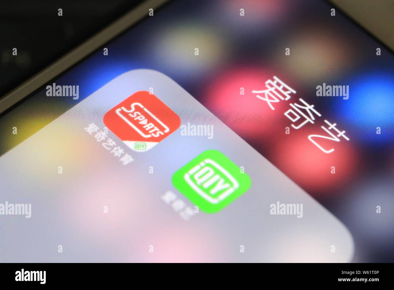 --FILE -- un telefono cellulare utente guarda le icone delle applicazioni mobile cinese di sport online video streaming platform iQiyi Sport, sinistra e cinesi sul Foto Stock