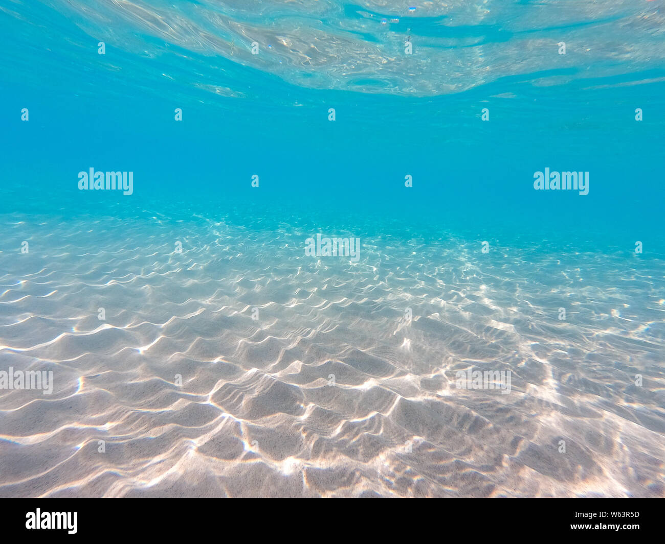 Sfondo subacqueo con sabbia di mare basso. Bella la texture del mare e l'acqua dell'oceano. Foto Stock