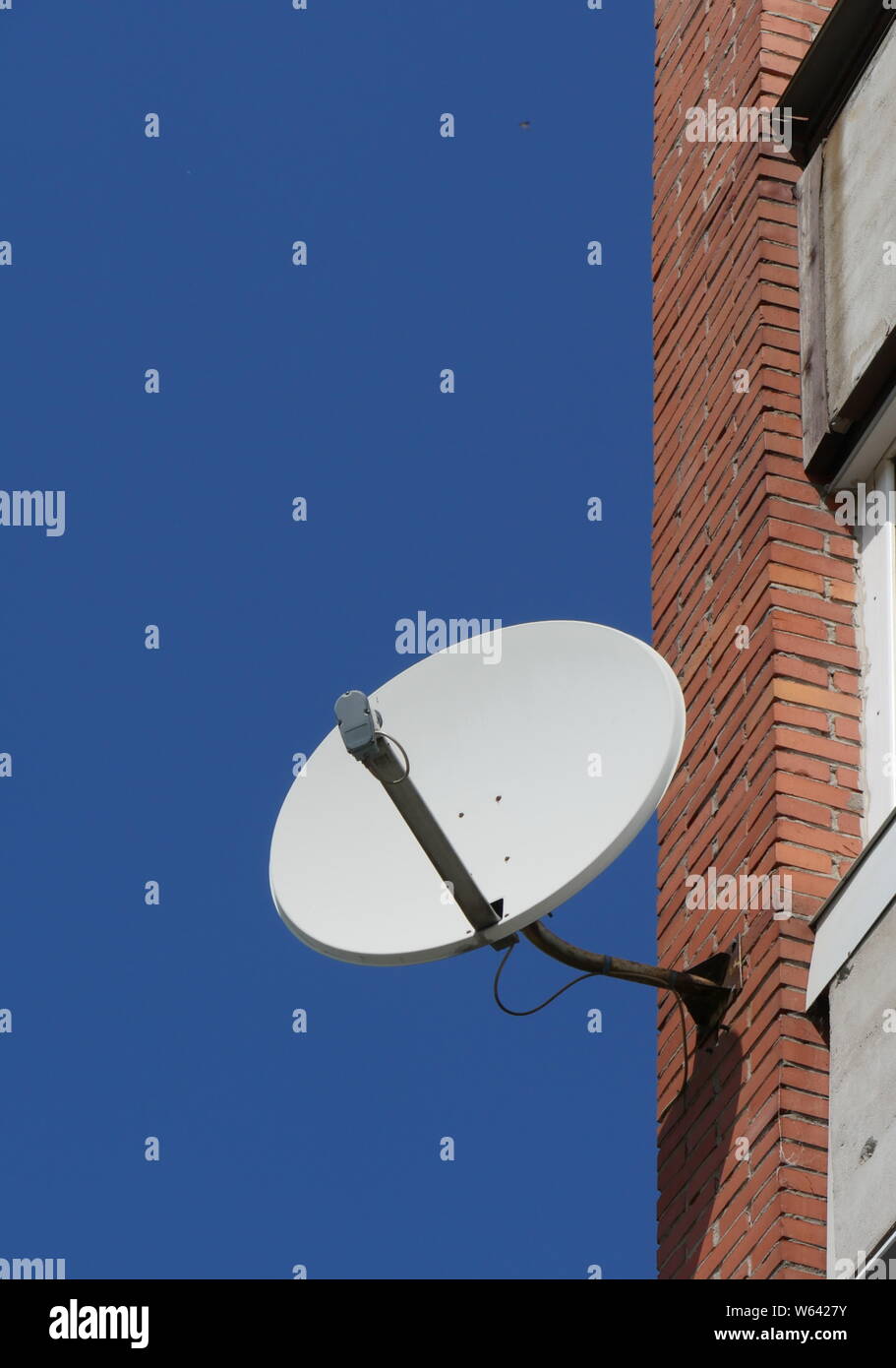 Antenna satellitare sulla parete della casa Foto Stock