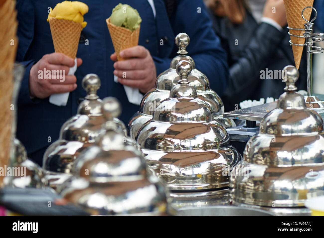 Gelateria in Italia.Gold caps. Il commercio in strada. Mani di persone con waffle tazze Foto Stock
