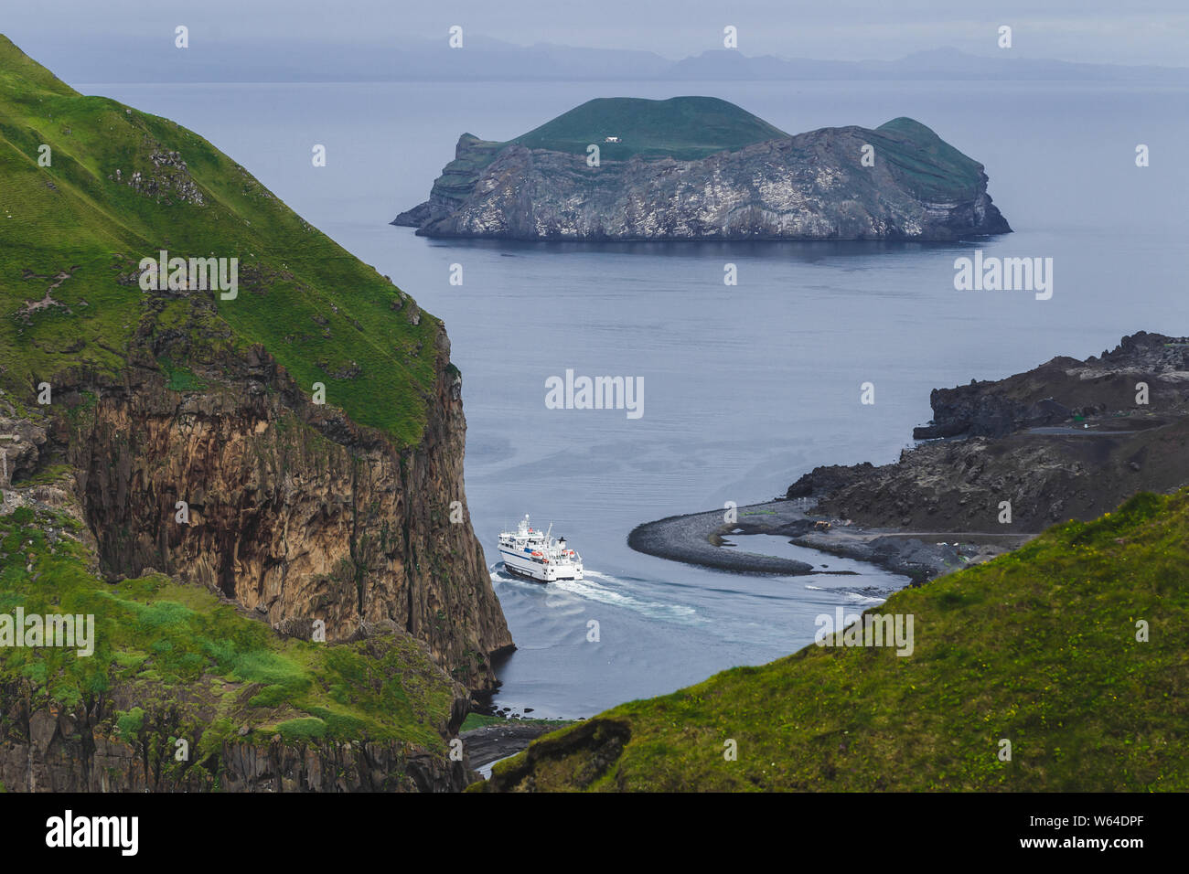 Passeggeri dei traghetti nel porto di Vestmannaeyjar, Islanda. Isola di Ellidaey sullo sfondo. Vista aerea. Paesaggio nordico. Foto Stock