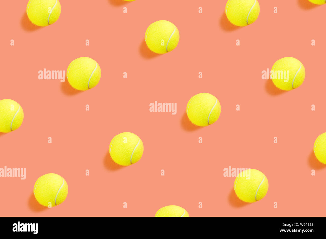 Palla da tennis pattern sul corallo arancione sfondo astratto. Gioco, pratica, il concetto di concorrenza. Colori alla moda Foto Stock