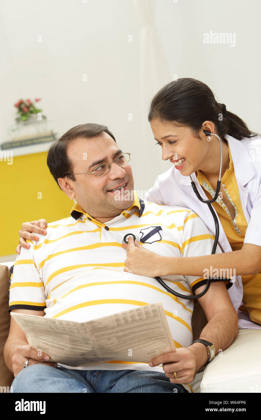 Dottoressa che esamina il padre con stetoscopio Foto Stock