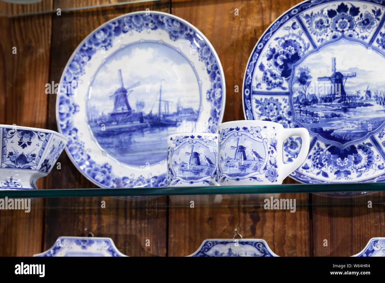 Zaanse Schans, Paesi Bassi - 25 Febbraio 2017: Decorative di piastre in ceramica e le tazze con dipinti blu stand sul ripiano in vetro in tourist souvenir shop Foto Stock