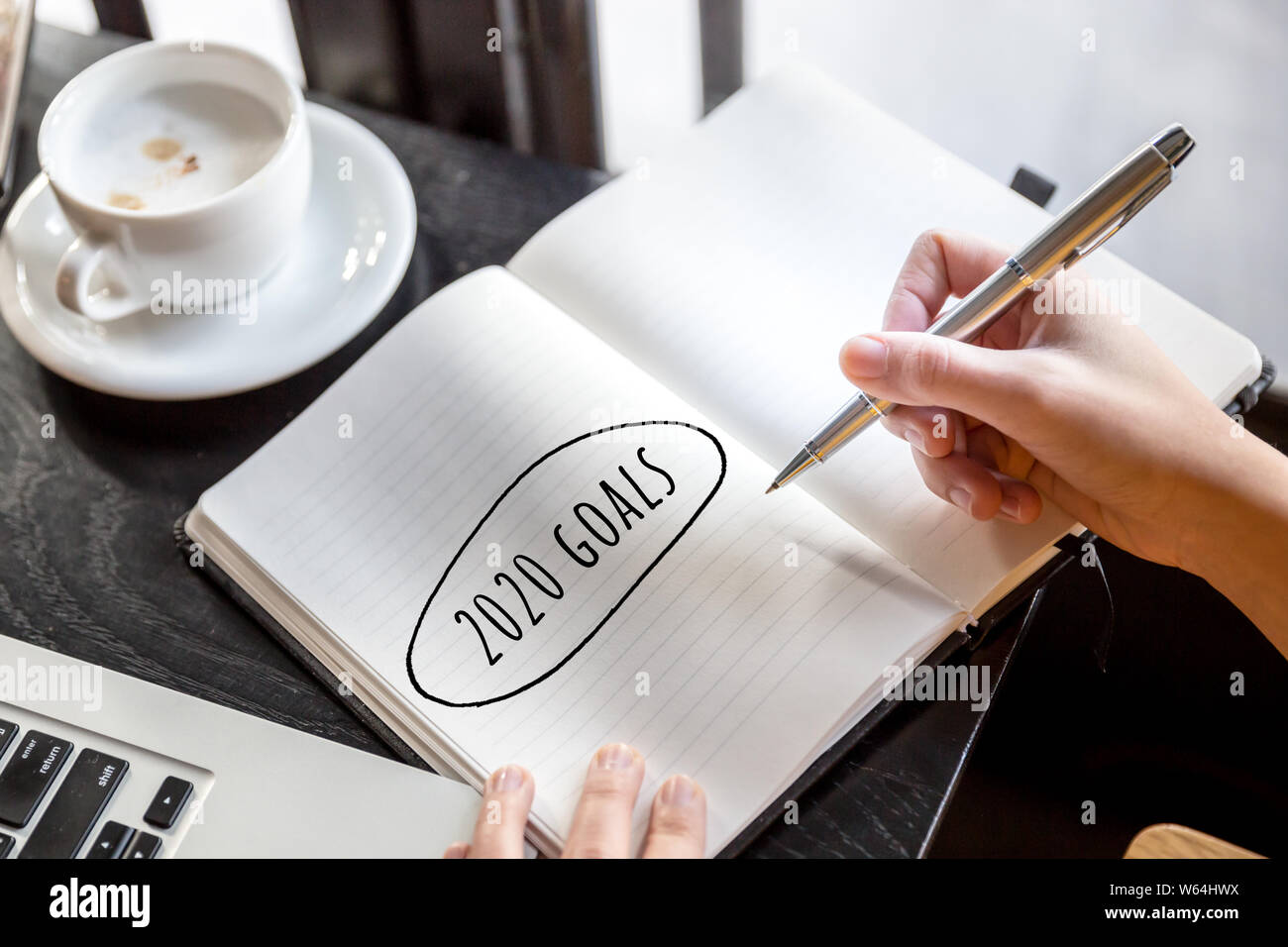 2020 obiettivi concetti con testo in Blocco note con tazza di caffè e laptop in cafe sfondo. Motivazione di business i concetti di strategia di idee. Foto Stock