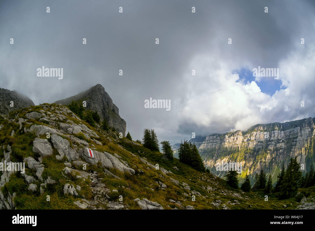 Sentiero di montagna che conduce al picco di nebbia di Sigriswiler Rothorn; sullo sfondo la Güggisgrat con macchie di sole Foto Stock