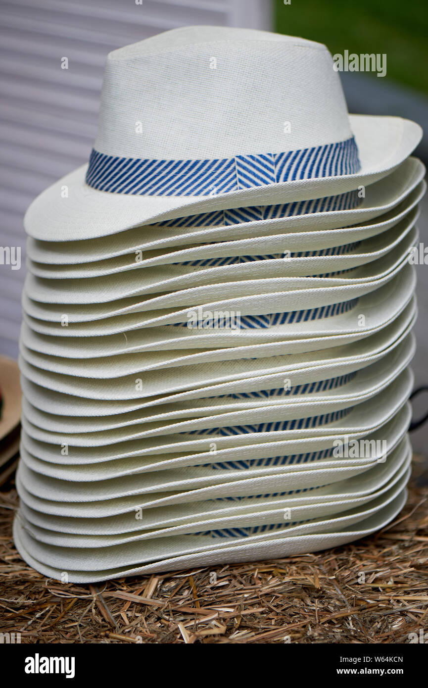 Una pila di cappelli bianchi con un nastro di colore blu.Vendita di cappelli.  Stile italiano Foto stock - Alamy
