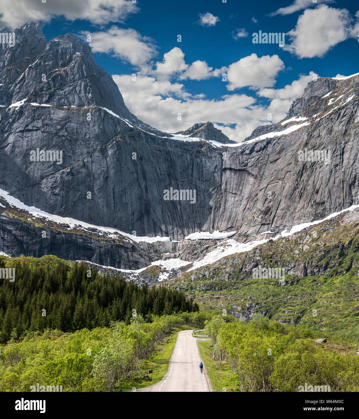 Femmina ciclista su strada a Nusfjord, Isole Lofoten in Norvegia. Foto Stock