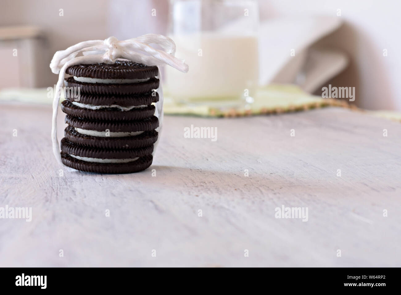 Deliziosi biscotti al cioccolato con crema alla vaniglia e fresco bicchiere di latte in background/ immagine concettuale del dolce salutare prima colazione Foto Stock