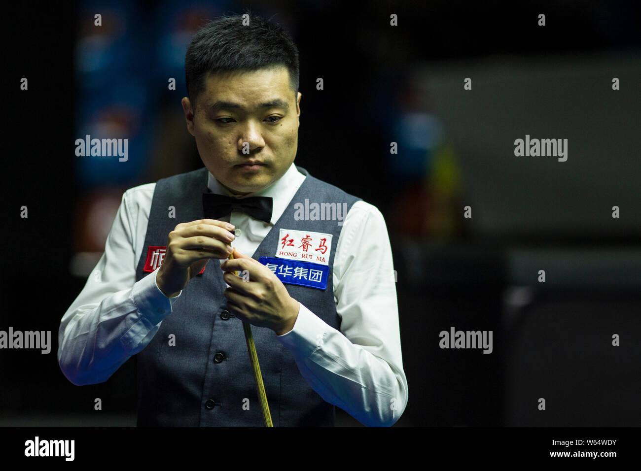 Ding Junhui della Cina i gessi spunto come egli ritiene che un colpo a Robert Milkins di Inghilterra nella loro seconda partita durante il 2018 Mondo aperto Biliardo Foto Stock