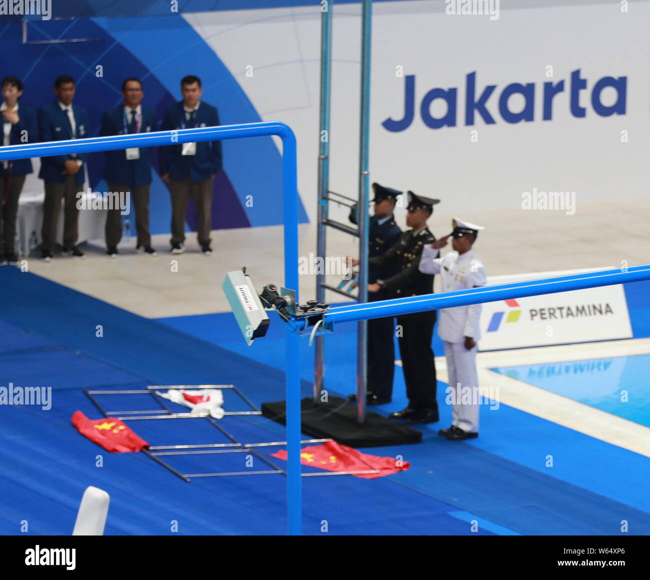 Il cinese e il giapponese bandiere nazionali cadono verso il basso in corrispondenza di una vittoria cerimonia di uomini 200m Freestyle Finale durante il XVIII Giochi Asiatici Jakarta-Palembang 20 Foto Stock
