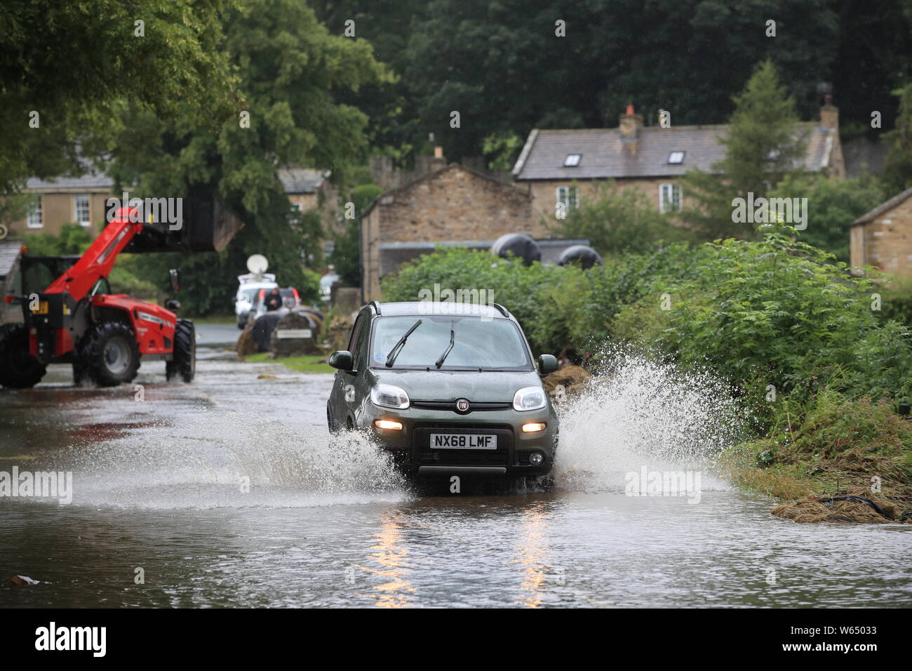 Un auto viene guidata attraverso l'acqua di allagamento nello Yorkshire, dopo le parti della regione avevano fino a 82.2mm di pioggia in 24 ore il martedì. Foto Stock