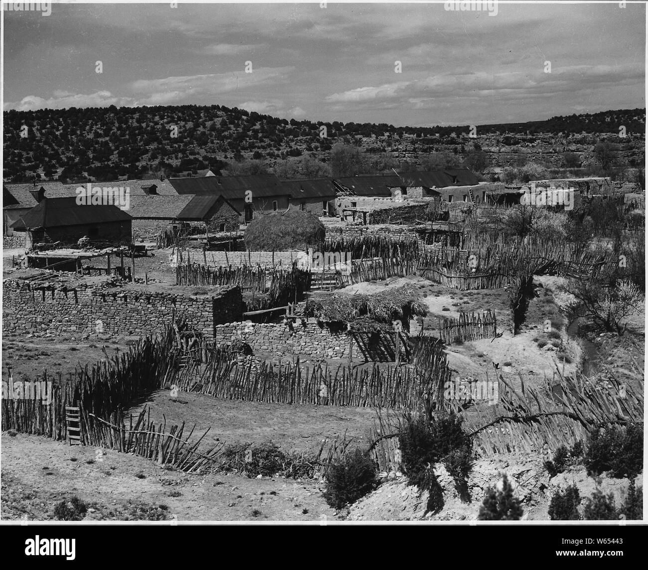 El Cerrito, San Miguel County, Nuovo Messico. Questa foto è stata scattata dietro una fila di case che faccia . . .; Portata e contenuto: Full didascalia recita come segue: El Cerrito, San Miguel County, Nuovo Messico. Questa foto è stata scattata dietro una fila di case che si affacciano sulla piazza. Le strutture di servizio e pole stalle sono disposti in modo da sfruttare appieno ogni piede quadrato di spazio. A destra è il fosso di irrigazione che segna il confine del villaggio su tre lati. Foto Stock