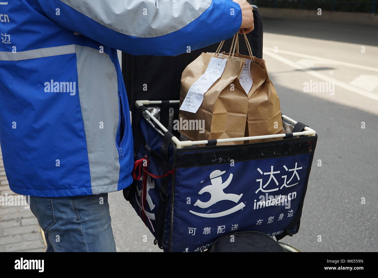 --FILE--un cibo deliveryman di Dada offre un ordine in Cina a Shanghai, 25 agosto 2018. Dada-JD Daojia, un cinese online negozio di generi alimentari e la consegna della ditta, Foto Stock