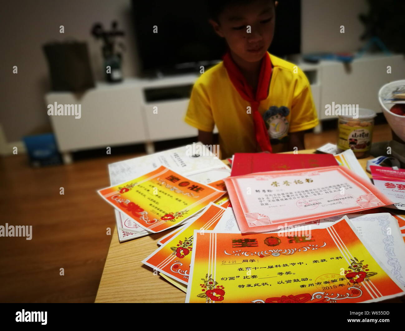 11-anno-vecchio ragazzo cinese Shao Zijin da Quzhou sperimentale Scuola Primaria mostra il suo degli attestati di merito a casa durante la sua vacanza estiva in Quzho Foto Stock